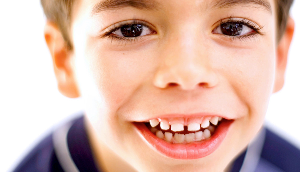 Junge zeigt Zähne