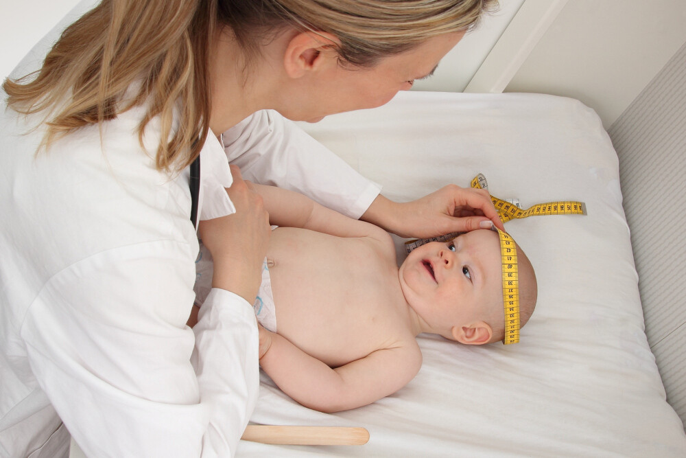 Ärztin misst Kopfumfang eines Babys
