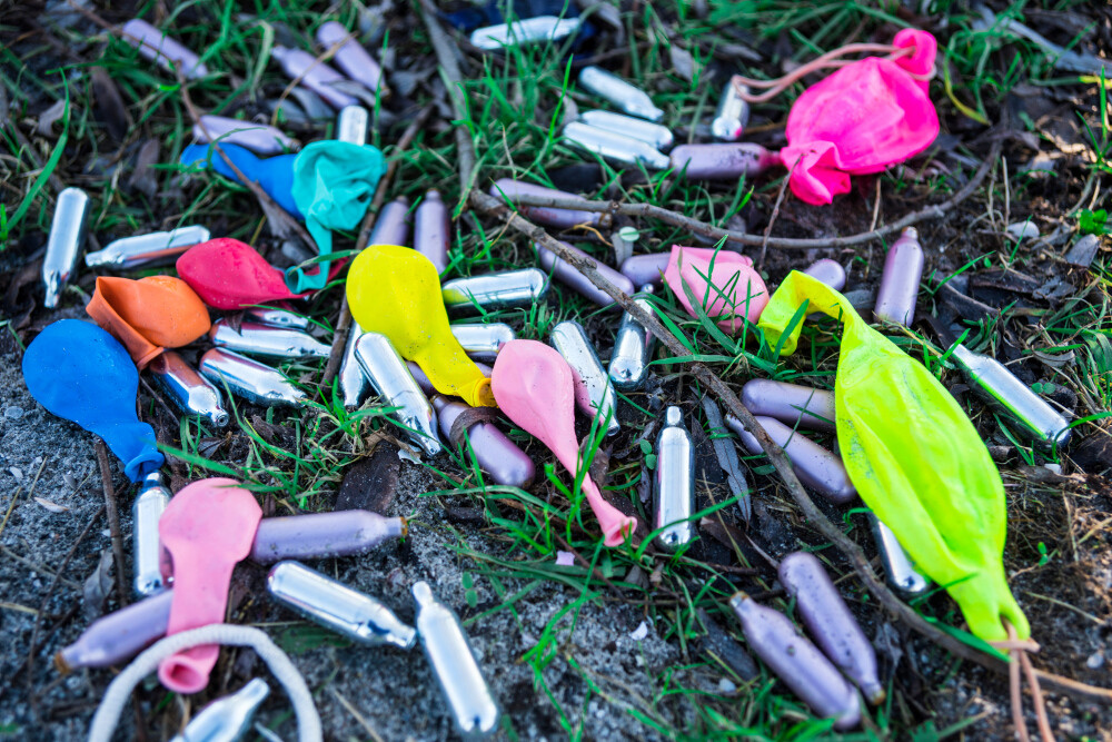 Farbige Luftballons und Kartuschen liegen auf dem Boden