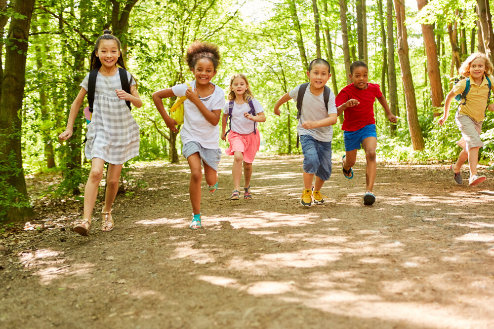 Gruppe Kinder beim Rennen in der Natur im Sommer