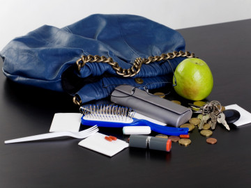Blaue Handtasche und ausgekippter Inhalt