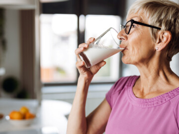 Frau trink einen Schluck Milch aus einem Glas